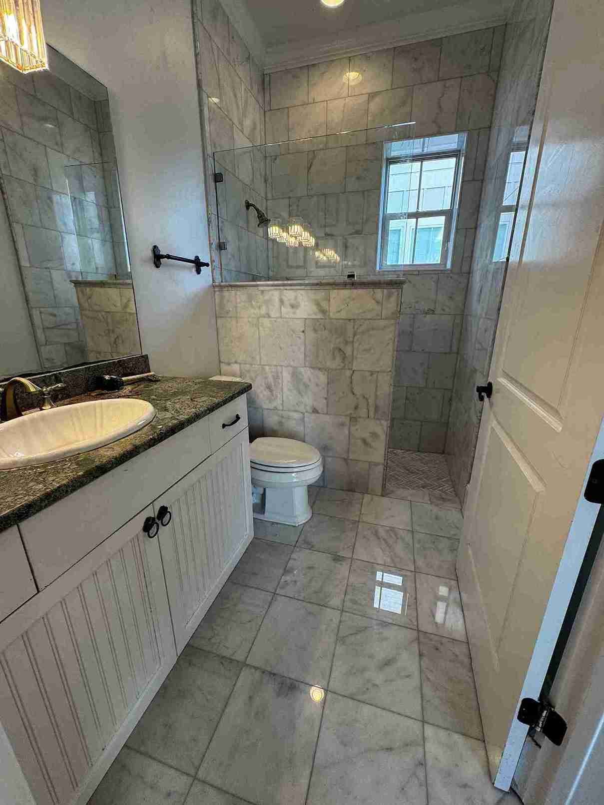 Full bathroom with marble tile shower and vanity installed by Barys Tile in Lynn Haven